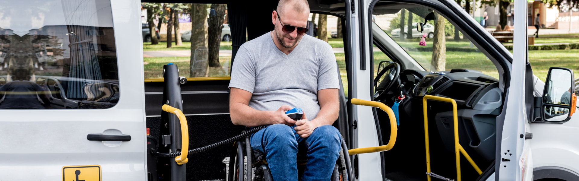 man sitting on wheelchair inside a van